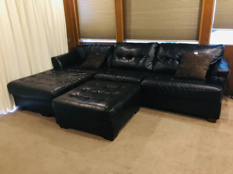 Slide: The Image of Luxurious black leather sectional sofa with matching ottoman in a cozy living room. - 20