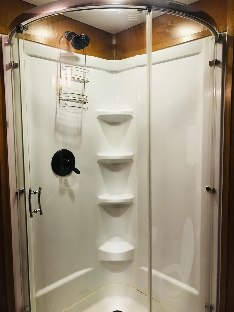 Slide: The Image of Luxurious shower in 2014 Bravada Imagination Trip 11 RV with glass doors and shelving. - 3