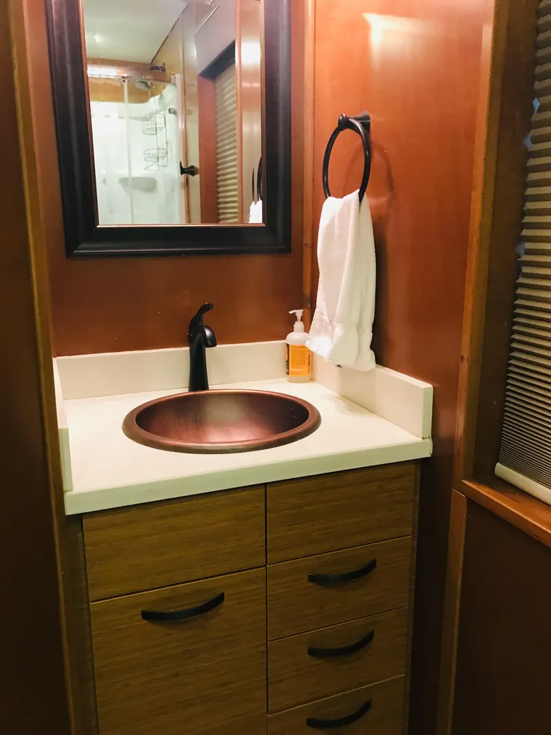 Slide: The Image of 2014 Bravada Imagination Trip 11 bathroom with modern sink and wooden cabinetry. - 4