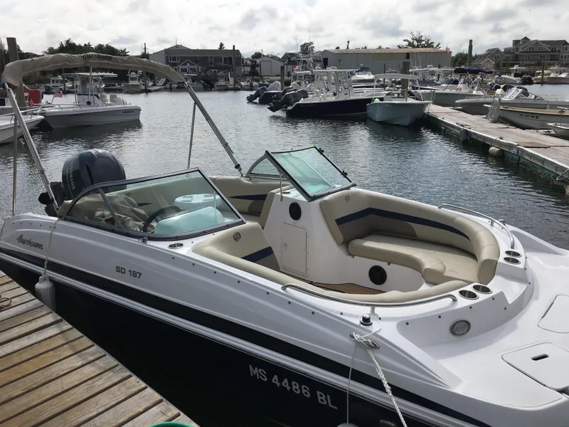 Slide: The Image of 2019 Hurricane SD 187 boat docked in a marina, featuring spacious seating and sleek design. - 0
