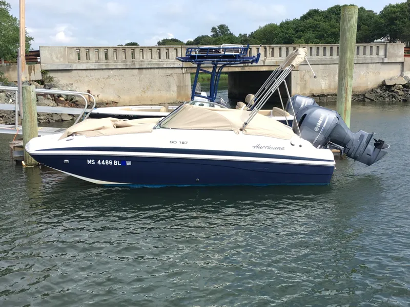 Slide: The Image of 2019 Hurricane SD 187 boat docked in calm water, featuring a sleek design and outboard motor. - 1