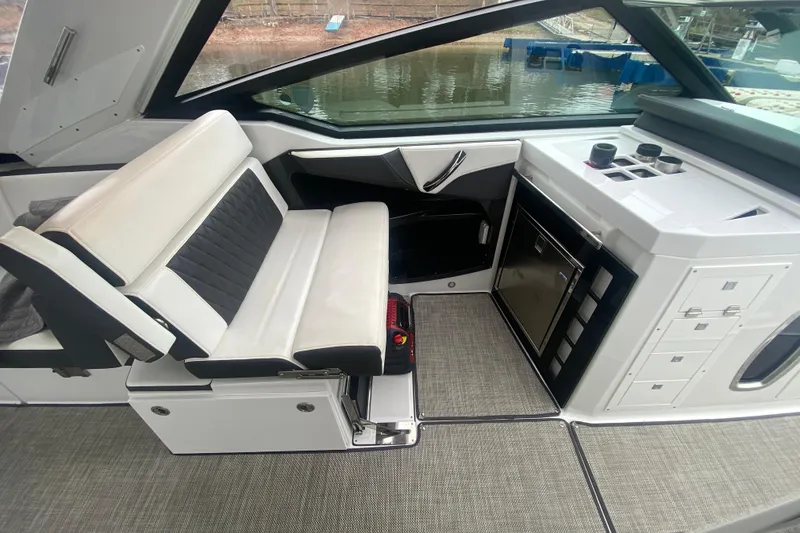 Slide: The Image of 2020 Monterey 385 Super Express interior with seating and kitchenette, docked by the water. - 13