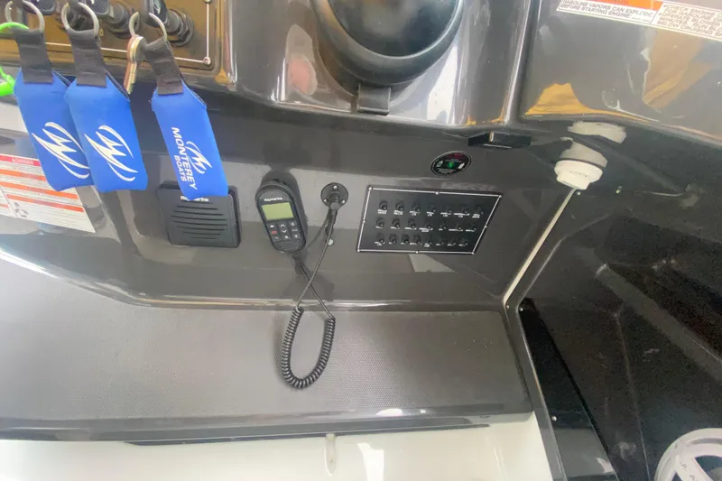 Slide: The Image of Control panel of a 2020 Monterey 385 Super Express boat with keychains and communication device. - 17