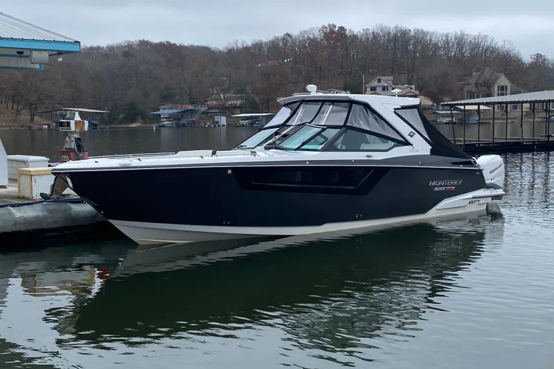 Slide: The Image of 2020 Monterey 385 Super Express boat docked on a calm lake with wooded shoreline. - 35
