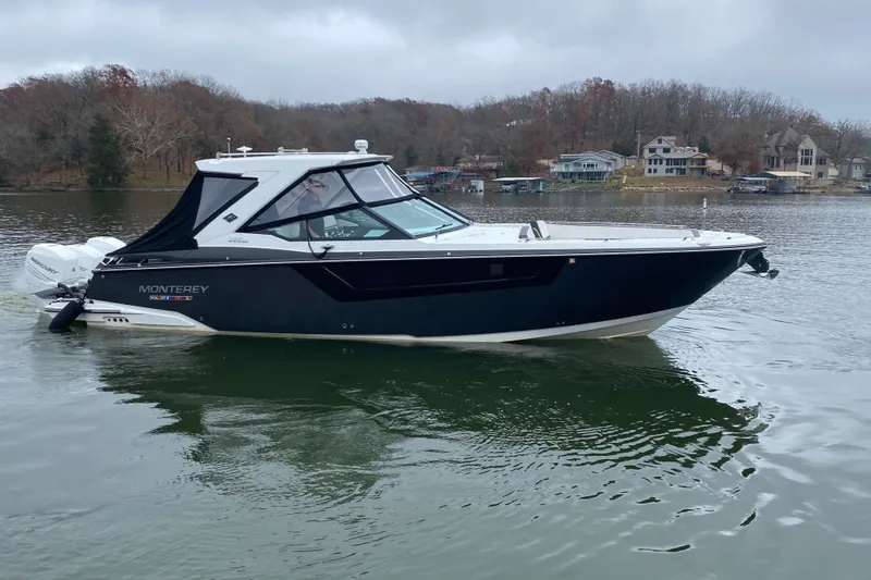 Slide: The Image of 2020 Monterey 385 Super Express boat on a calm lake with houses in the background. - 4