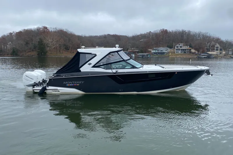 Slide: The Image of 2020 Monterey 385 Super Express boat on a calm lake with houses in the background. - 5