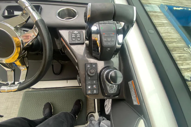 Slide: The Image of Cockpit controls of a 2020 Monterey 385 Super Express boat, featuring steering wheel and throttle. - 11