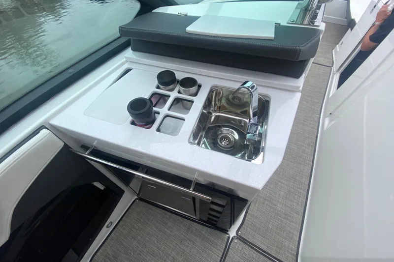 Slide: The Image of 2020 Monterey 385 Super Express boat kitchenette with sink and cup holders. - 16