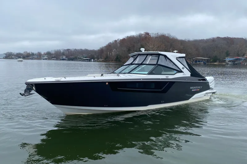 Slide: The Image of 2020 Monterey 385 Super Express boat cruising on a calm lake. - 2