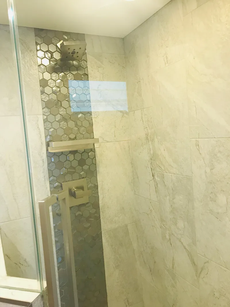 Slide: The Image of Modern bathroom shower with hexagonal tile accent, glass door, and marble walls. Adonia Inspiration Trip #9, 2019. - 19