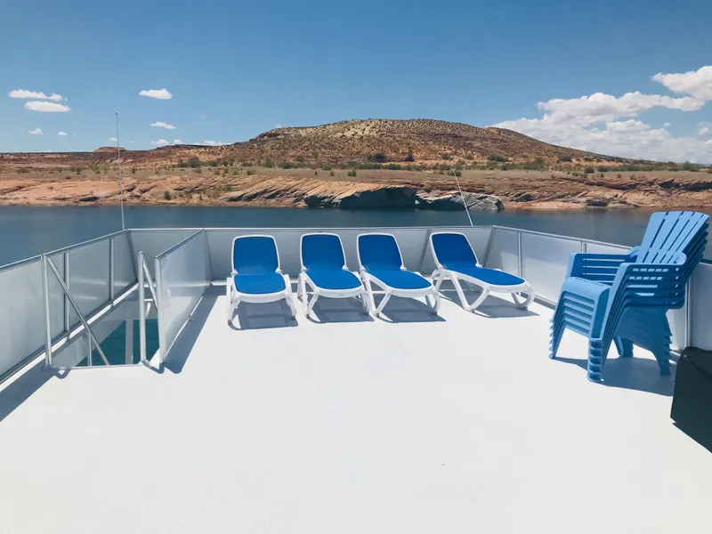 Slide: The Image of Sun deck with blue loungers on Adonia Inspiration Trip #9, 2019, overlooking serene waters and hills. - 39