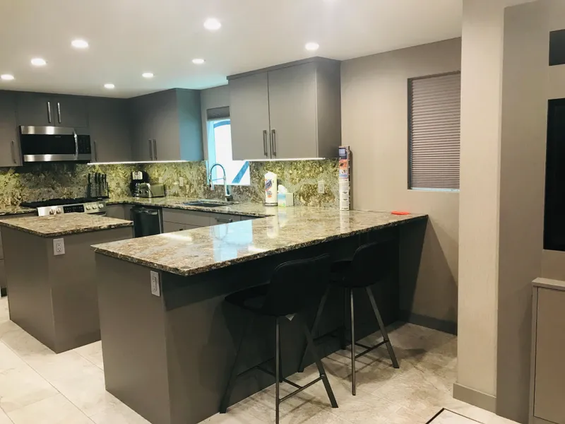 Slide: The Image of Modern kitchen with granite countertops, gray cabinets, and bar stools; Adonia Inspiration Trip #9, 2019. - 4