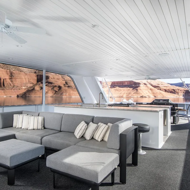 Slide: The Image of Luxurious Adonia yacht interior with gray sofa and lake view. - 10