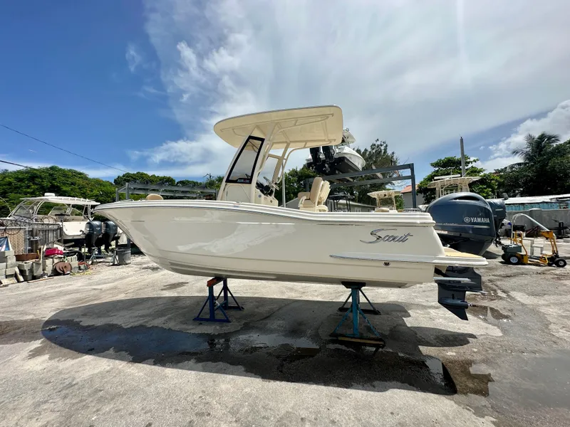 Slide: The Image of 2025 Scout 215 XSF boat on stands in a sunny outdoor marina. - 11