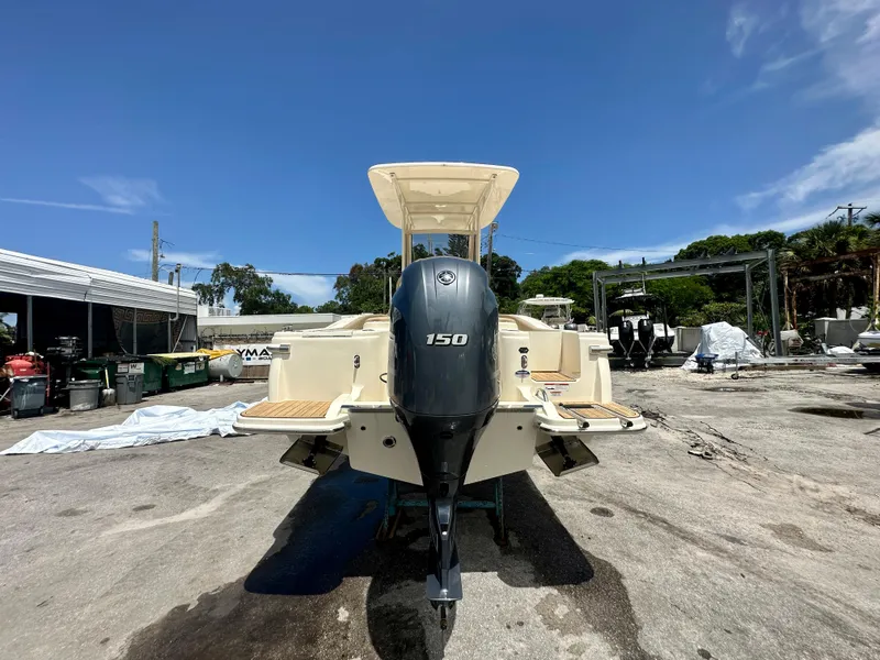 Slide: The Image of 2025 Scout 215 XSF boat with 150 HP engine in a boatyard. - 2