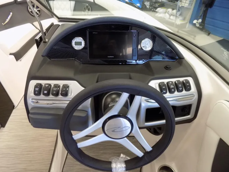 Slide: The Image of 2023 Regal 21 OBX boat dashboard with steering wheel and control panel. - 12
