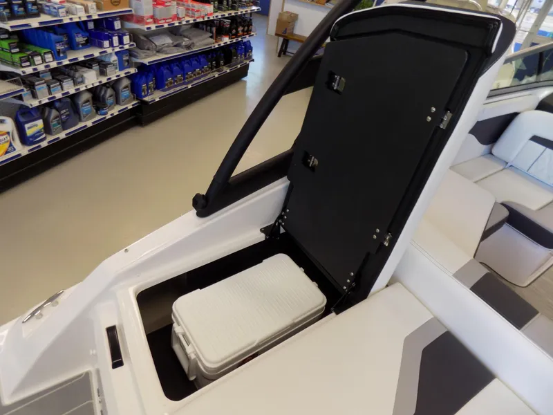 Slide: The Image of 2023 Regal 21 OBX boat with open storage compartment and cooler inside. - 23