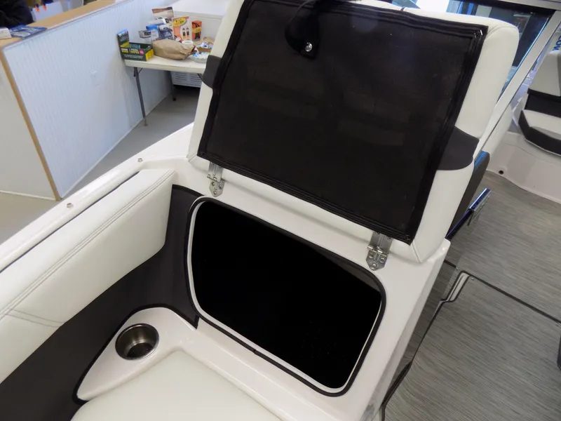 Slide: The Image of 2023 Regal 21 OBX boat interior storage compartment with open lid and cup holder. - 8