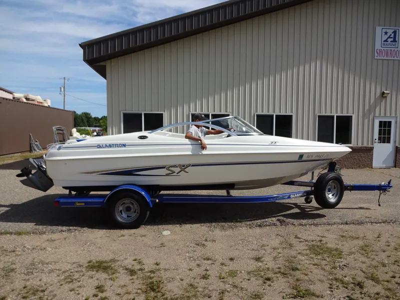 The Image of 2005 Glastron SX195 boat on trailer outside a building, side view. - 1