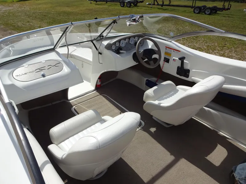 Slide: The Image of 2005 Glastron SX195 boat interior with white seats and dashboard. - 10