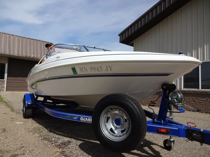 Slide: The Image of 2005 Glastron SX195 boat on trailer, parked outside a building. - 2