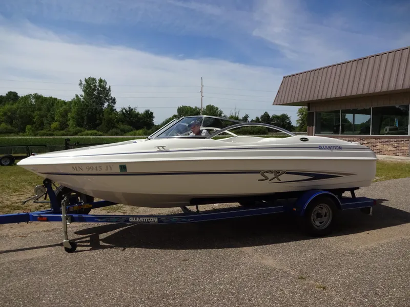 Slide: The Image of 2005 Glastron SX195 boat on trailer, parked outdoors near a building. - 5
