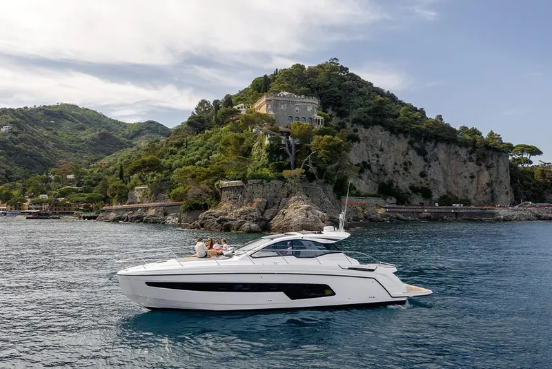 Slide: The Image of 2023 Azimut A45 yacht cruising near a scenic coastal cliff. - 0
