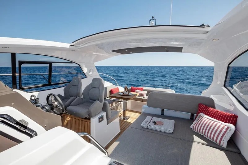 Slide: The Image of 2023 Azimut A45 yacht interior with ocean view, modern seating, and dining area. - 15