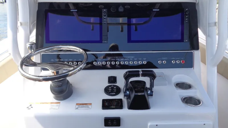 Slide: The Image of 2017 Sportsman 312 Open boat dashboard with dual screens and steering wheel. - 11