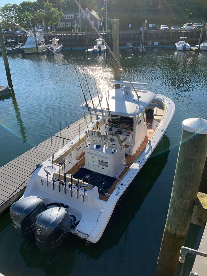 Slide: The Image of 2017 Sportsman 312 Open fishing boat docked with dual engines and fishing rods. - 20