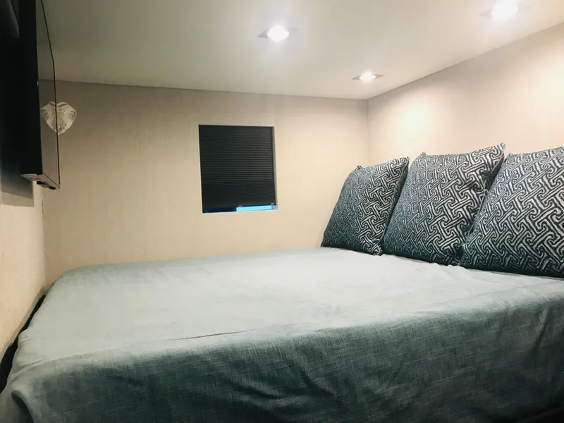 Slide: The Image of Cozy bedroom in 2018 Adonia Adonis Trip 3 RV with patterned pillows and soft lighting. - 15