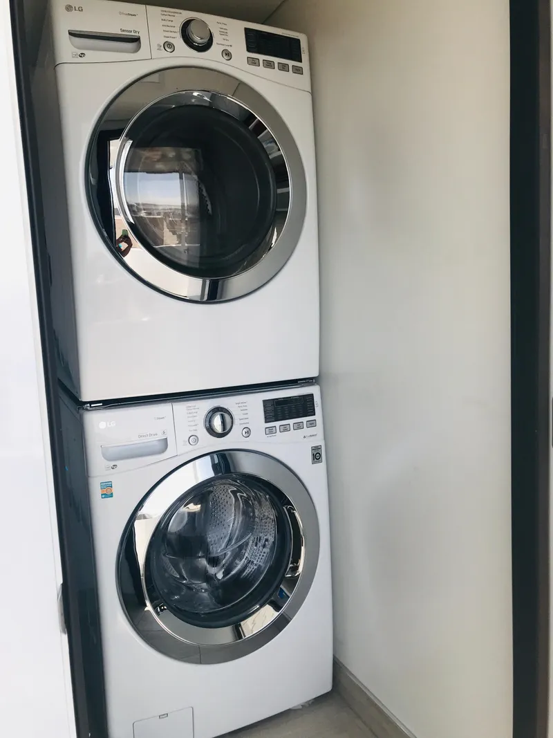 Slide: The Image of Stacked Adonia Adonis Trip 3 washer and dryer set in a compact laundry space. - 27