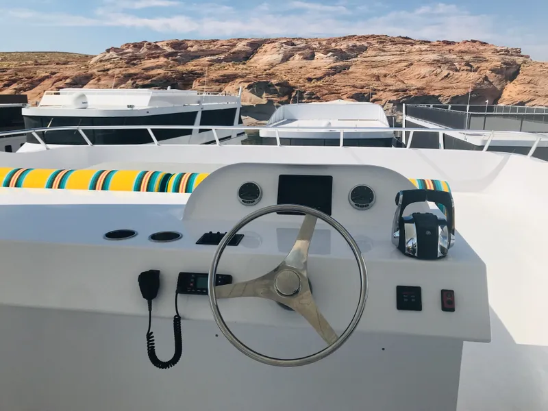 Slide: The Image of Steering wheel of 2018 Adonia Adonis Trip 3 boat with rocky landscape background. - 34