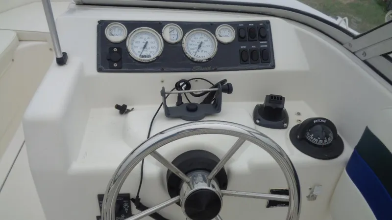 Slide: The Image of 1999 Seaswirl Striper 21 DC boat dashboard with steering wheel and gauges. - 12