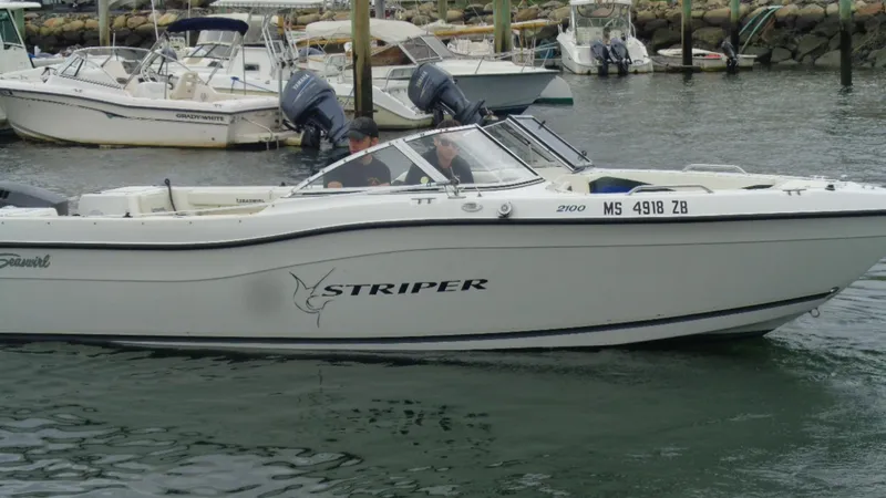 Slide: The Image of 1999 Seaswirl Striper 21 DC boat in marina, side view, with outboard motors. - 2