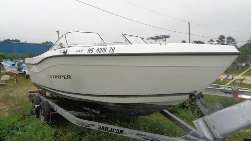Slide: The Image of 1999 Seaswirl Striper 21 DC boat on trailer, side view, outdoors. - 4