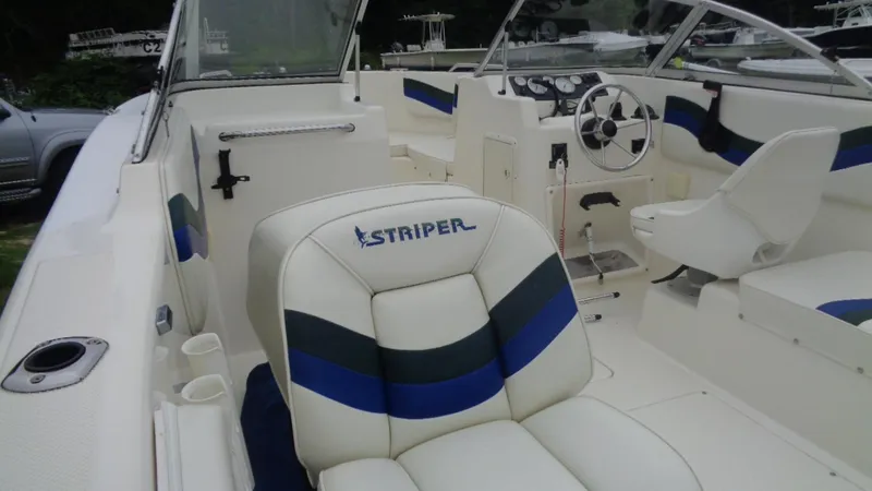 Slide: The Image of 1999 Seaswirl Striper 21 DC boat interior with white and blue seating. - 7