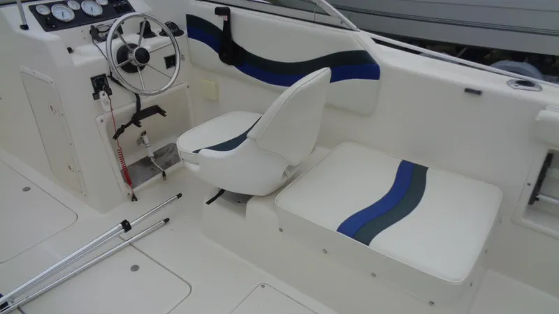 Slide: The Image of 1999 Seaswirl Striper 21 DC boat interior with steering wheel and seating. - 8