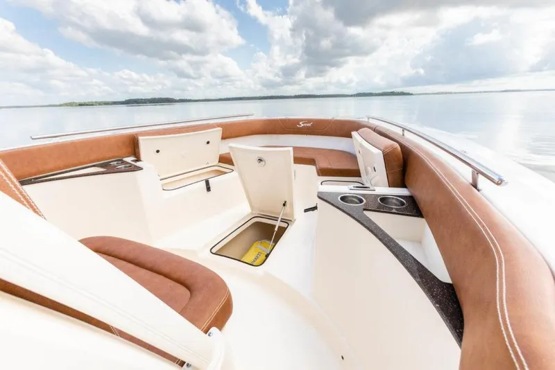 Slide: The Image of 2023 Scout 277 LXF boat interior with brown seating and storage compartments. - 11