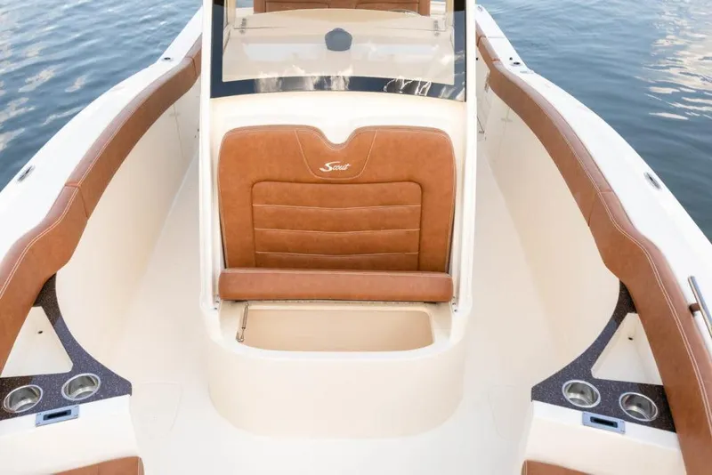 Slide: The Image of 2023 Scout 277 LXF boat interior with brown seating and cup holders. - 14