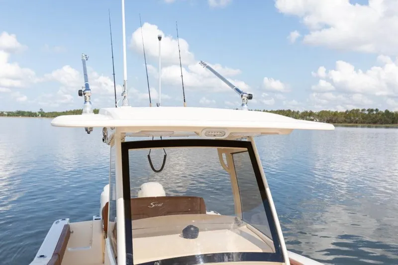 Slide: The Image of 2023 Scout 277 LXF boat on calm water with fishing rods. - 15