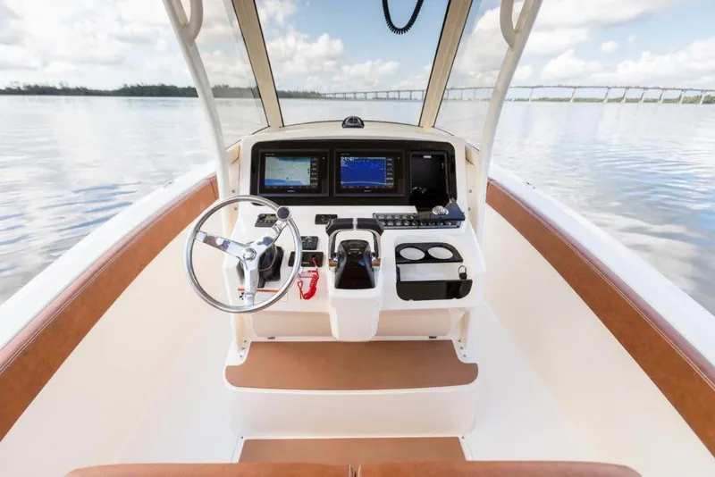 Slide: The Image of 2023 Scout 277 LXF boat dashboard with steering wheel and navigation screens. - 17