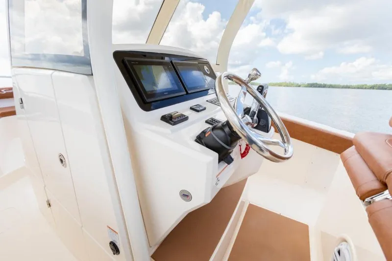 Slide: The Image of 2023 Scout 277 LXF boat helm with modern controls and steering wheel. - 18