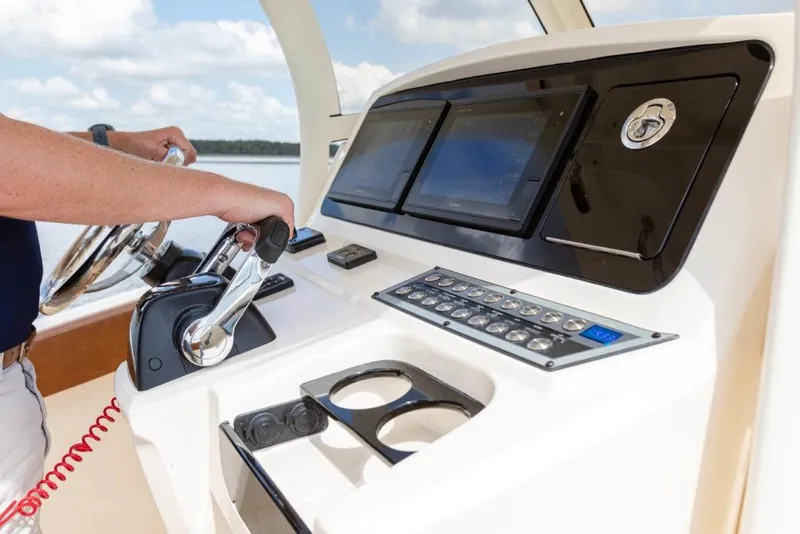 Slide: The Image of 2023 Scout 277 LXF boat dashboard with steering wheel and control panel. - 19