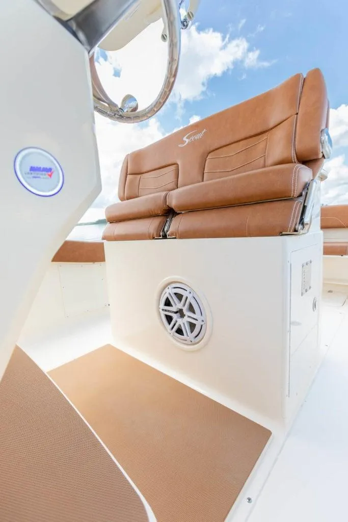 Slide: The Image of 2023 Scout 277 LXF boat interior with brown leather seats and speaker. - 21