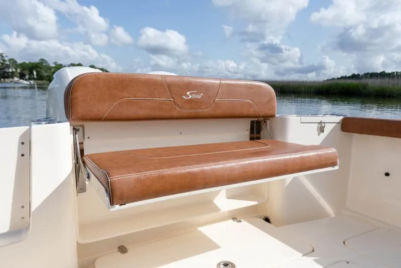Slide: The Image of 2023 Scout 277 LXF boat with brown leather seating, scenic water background. - 23