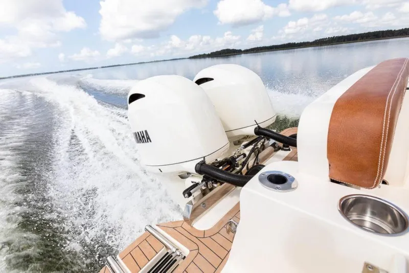 Slide: The Image of 2023 Scout 277 LXF boat with twin Yamaha engines cruising on a lake. - 25