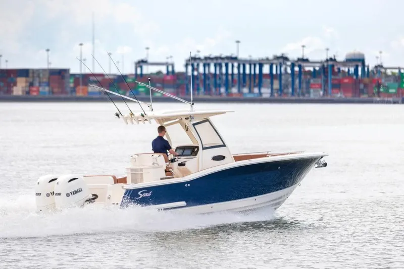 Slide: The Image of 2023 Scout 277 LXF boat cruising near a port. - 4
