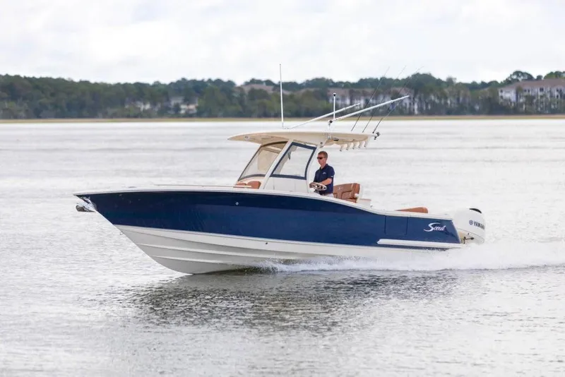 Slide: The Image of 2023 Scout 277 LXF boat cruising on a lake. - 5