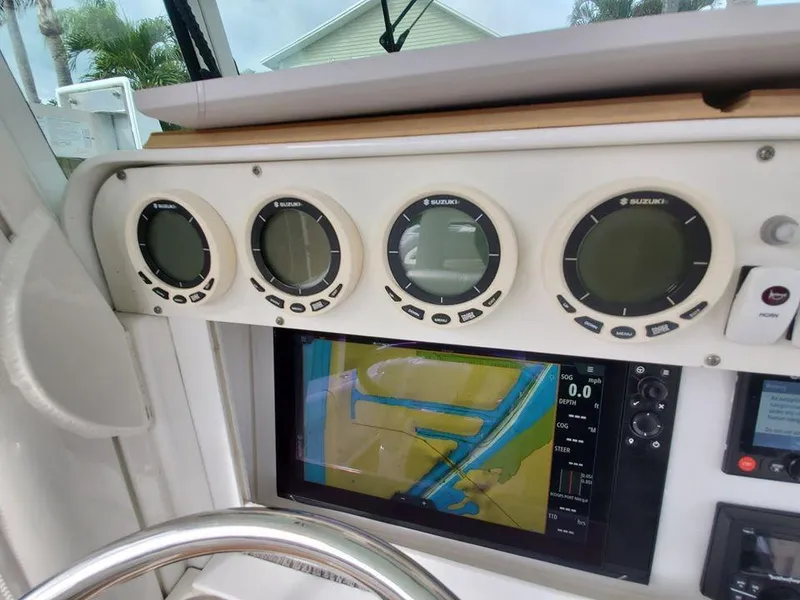 Slide: The Image of 2008 Everglades 350 CC boat dashboard with Suzuki gauges and navigation screen. - 17